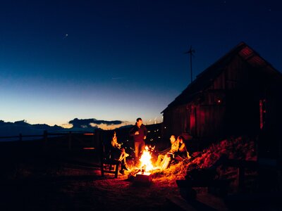 Abendstimmung am Lagerfeuer auf der Alm | © Urlaub am Bauernhof Kärnten/ Daniel Gollner Gruppe sitzt rund ums Lagerfeuer und genießt die Abendstimmung auf der Alm | © Urlaub am Bauernhof Kärnten/ Daniel Gollner