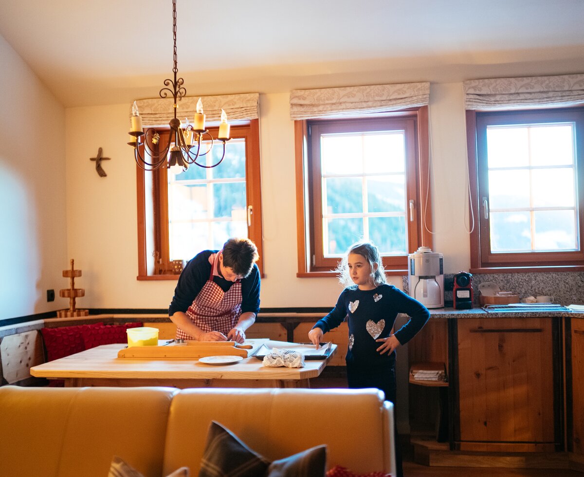 Frau und Mädchen backen gemeinsam Kekse in der Almküche auf der Sandrisser Hütte | © Urlaub am Bauernhof Kärnten / Daniel Gollner