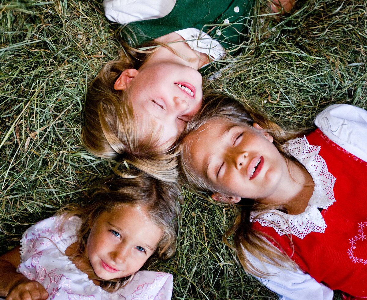 Kinder im Heu | © Urlaub am Bauernhof Kärnten / Tom Lamm Drei Kinder liegen im Heu | © Urlaub am Bauernhof Kärnten / Tom Lamm