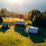 Zwei Almhütten von oben im Morgensonnenschein in Kärnten | © Urlaub am Bauernhof Kärnten / Daniel Gollner