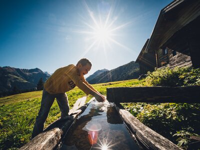 Bub wäscht sich im Brunnen die Hände | © Urlaub am Bauernhof Salzburg / Daniel Gollner 