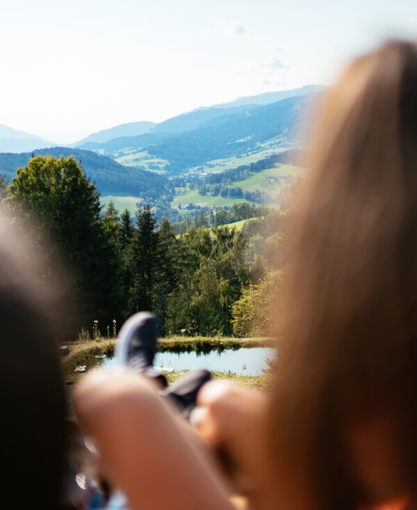 Blick auf Hügel in der Steiermark mit zwei Personen im Vordergrund  | © Urlaub am Bauernhof Steiermark / Daniel Gollner