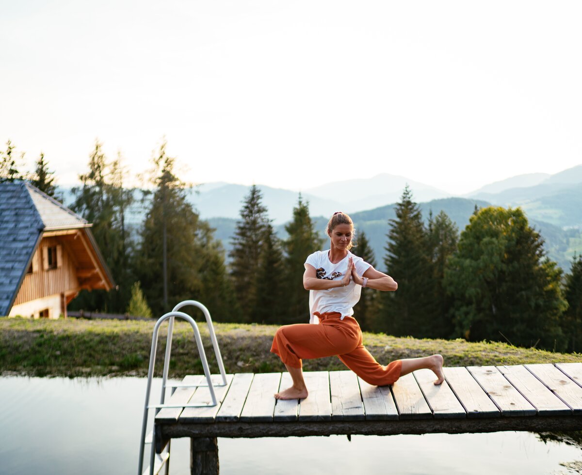 Yoga auf der Alm | © Urlaub am Bauernhof Steiermark / Daniel Gollner Frau macht Yoga am Hüttenteich am Steg | © Urlaub am Bauernhof Steiermark / Daniel Gollner