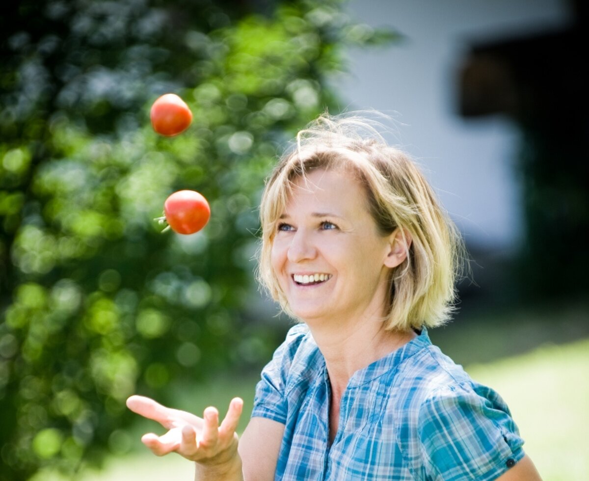Frau jongliert mit Tomaten | © Urlaub am Bauernhof Burgenland / Andi Bruckner Frau jongliert mit 2 Tomaten im Garten | © Urlaub am Bauernhof Burgenland / Andi Bruckner