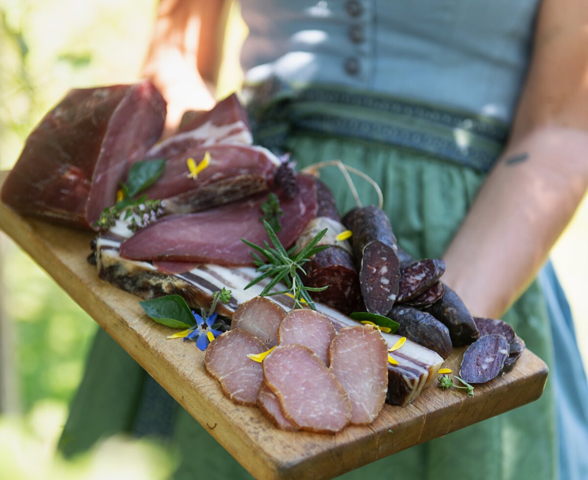 Jausenprodukte | © Carletto Photography / Urlaub am Bauernhof Kärnten Selbstgemachte Würstchen, Speck und Geselchtes am Holzbrettl präsentiert | © Carletto Photography / Urlaub am Bauernhof Kärnten