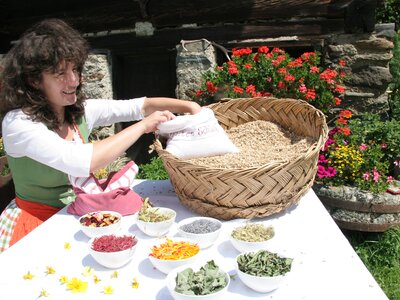 Bäuerin mit Blüten und Getreide | © Urlaub am Bauernhof Kärnten / Ernst Peter Prokop Bäuerin steht beim Tisch mit Blüten und Getreide | © Urlaub am Bauernhof Kärnten / Ernst Peter Prokop