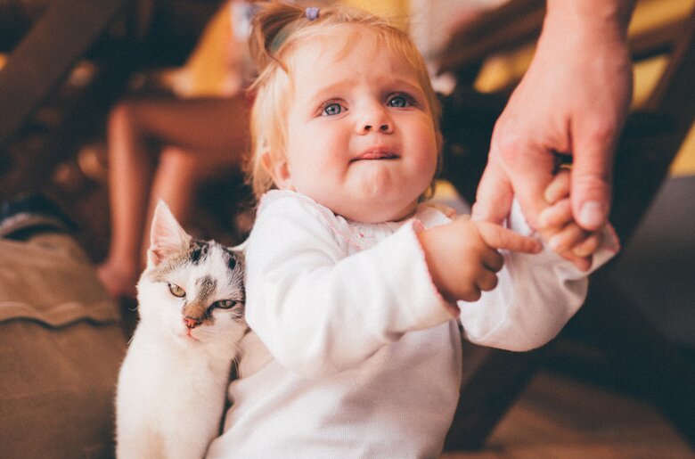 Katze lehnt sich an das Baby | © Urlaub am Bauernhof Kärnten / Daniel Gollner