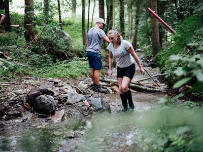 Mann und Frau mit Gummistiefel im Bach | © Urlaub am Bauernhof Kärnten/ Daniel Gollner