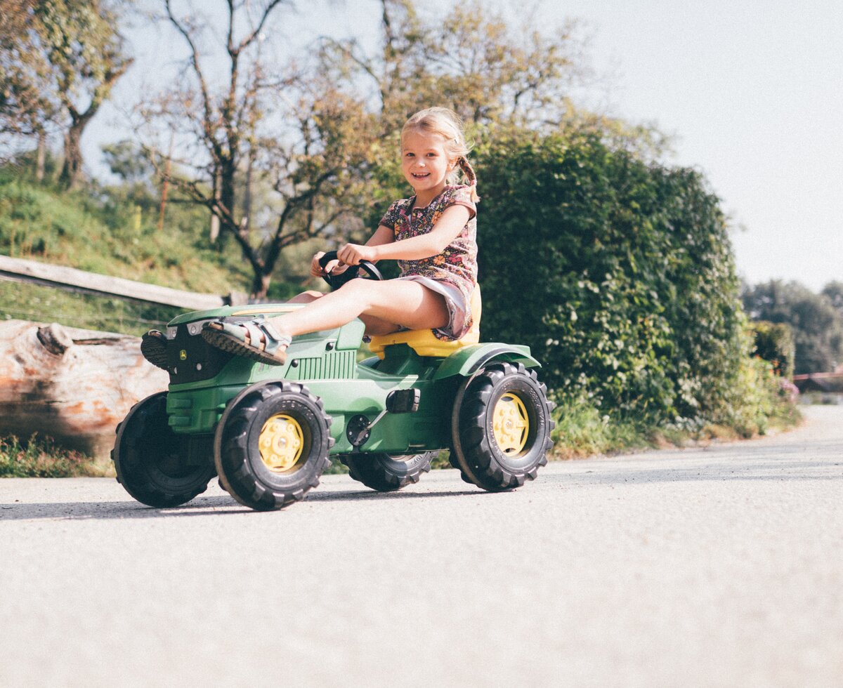 Kind sitzt auf Spielzeugtraktor | © Urlaub am Bauernhof Kärnten/ Daniel Gollner