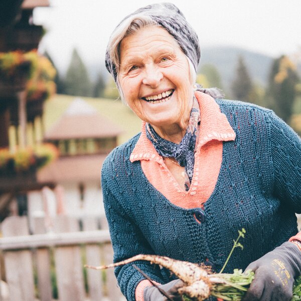 Frau mit Karotten in der Hand | © Urlaub am Bauernhof Kärnten / Daniel Gollner