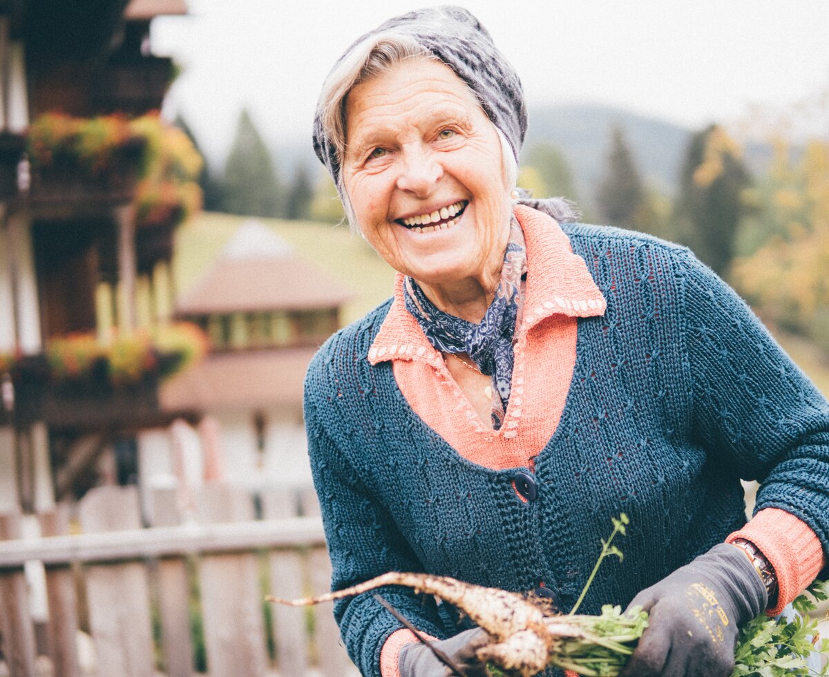 Frau mit Karotten in der Hand | © Urlaub am Bauernhof Kärnten / Daniel Gollner