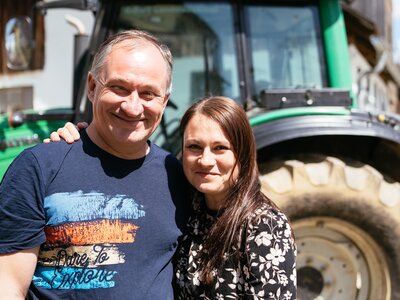 Vater und Tochter | © Urlaub am Bauernhof Kärnten / Daniel Gollner Vater und Tochter stehen vor Traktor und umarmen sich | © Urlaub am Bauernhof Kärnten / Daniel Gollner