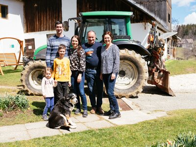 Familie Lichtenegger | © Urlaub am Bauernhof Kärnten / Daniel Gollner Die Familie steht vor einem Traktor | © Urlaub am Bauernhof Kärnten / Daniel Gollner