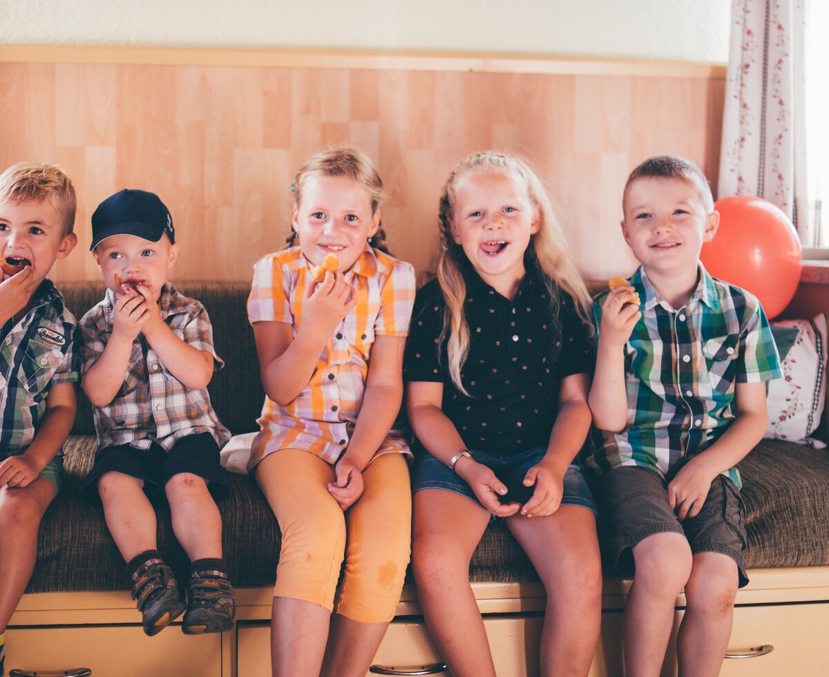 Kinder essen etwas Süßes | © Urlaub am Bauernhof Kärnten/ Daniel Gollner Kinder sitzen auf der Bank und essen etwas Süßes | © Urlaub am Bauernhof Kärnten/ Daniel Gollner