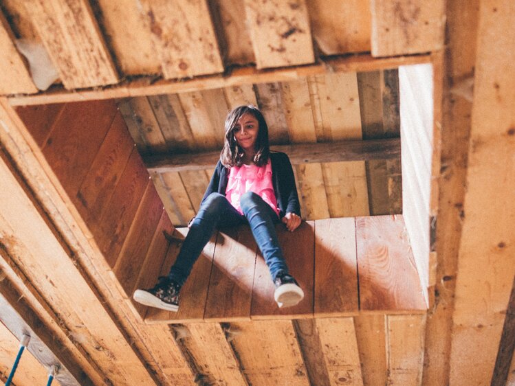 Mädchen sitzt auf der Holzdecke | © Urlaub am Bauernhof Kärnten/ Daniel Gollner