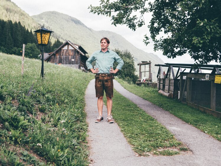 Bauer steht auf dem Weg und stützt die Arme ein | © Urlaub am Bauernhof Kärnten / Daniel Gollner