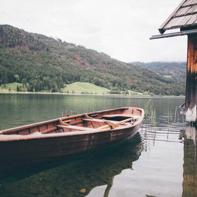 Boot im Wasser neben Bootshaus | © Urlaub am Bauernhof Kärnten / Daniel Gollner