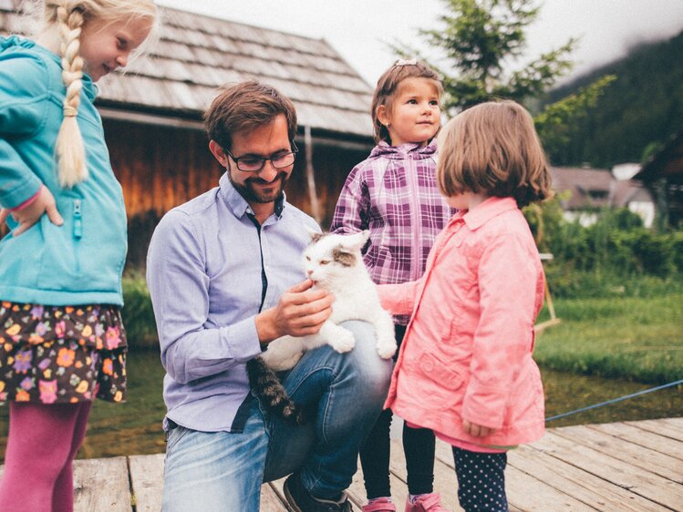 Mann und Kinder mit der Katze am Steg | © Urlaub am Bauernhof Kärnten / Daniel Gollner