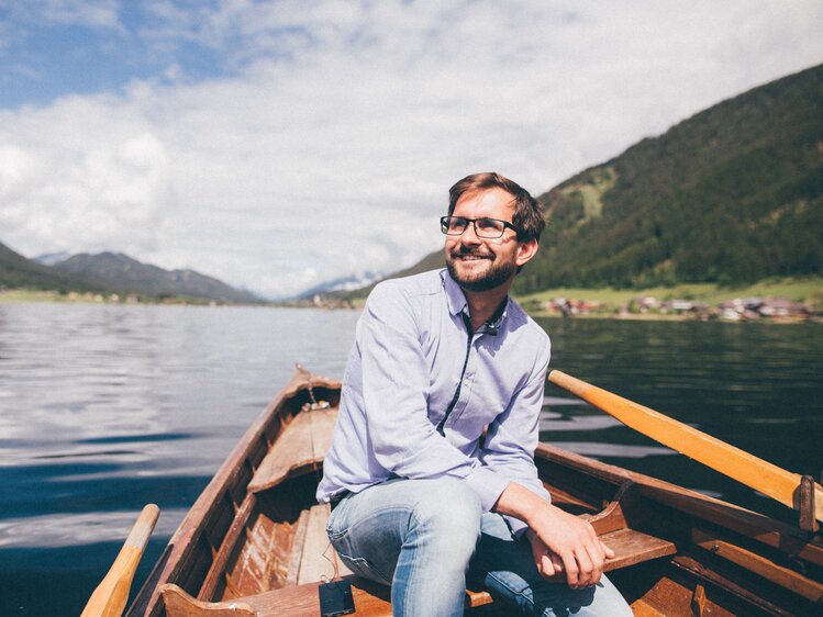 Mann sitzt im Boot auf dem Wasser | © Urlaub am Bauernhof Kärnten / Daniel Gollner