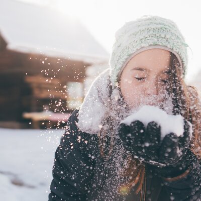 Mädchen pustet in den Schnee | © Urlaub am Bauernhof Kärnten / Daniel Gollner