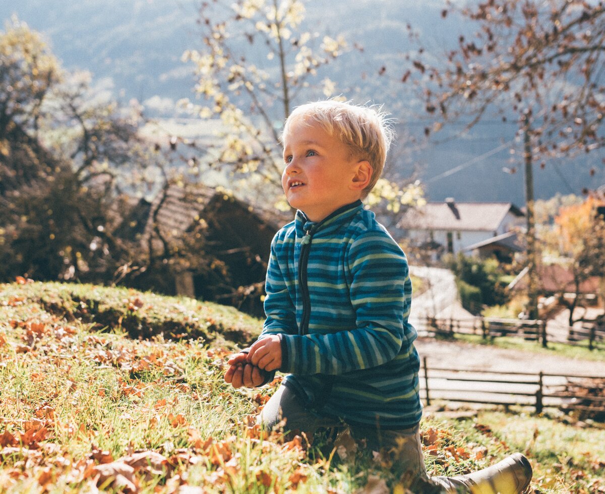 Bub auf der Wiese | © Urlaub am Bauernhof Kärnten / Daniel Gollner Bub kniet auf der Wiese | © Urlaub am Bauernhof Kärnten / Daniel Gollner