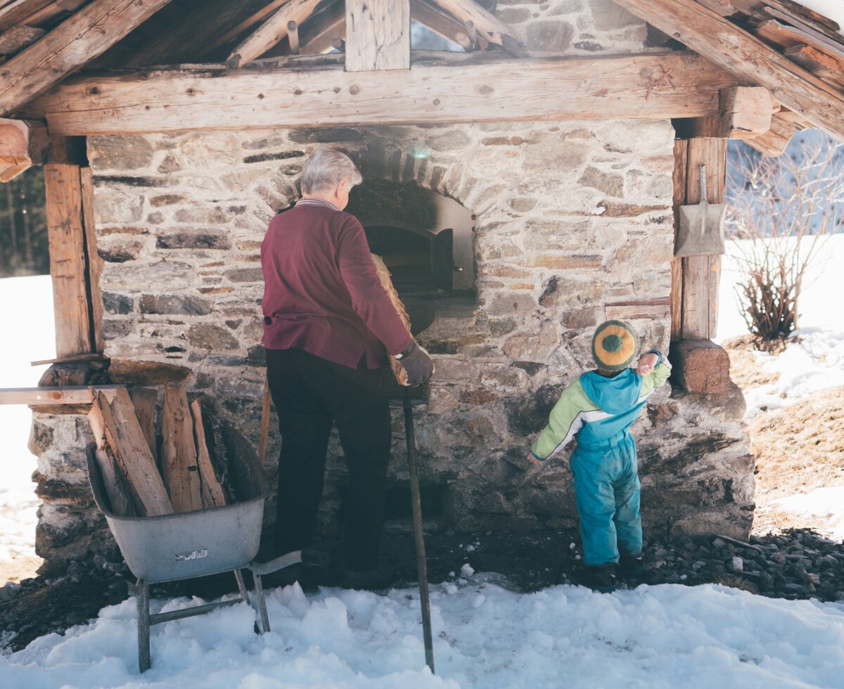 Bäuerin und Kind beim Ofen | © Urlaub am Bauernhof Kärnten / Daniel Gollner Bäuerin und Kind stehen beim Ofen | © Urlaub am Bauernhof Kärnten / Daniel Gollner