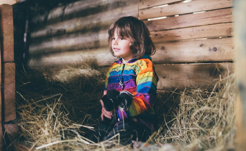 Mädchen hockt im Heu | © Urlaub am Bauernhof Kärnten/ Daniel Gollner