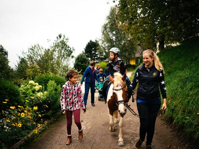 Familie spaziert mit dem Pferd am Weg | © Urlaub am Bauernhof Kärnten/ Daniel Gollner