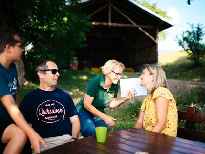 Familie sitzt draußen am Tisch | © Urlaub am Bauernhof Kärnten / Daniel Gollner
