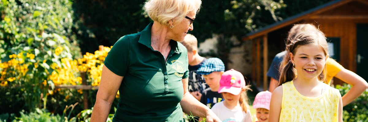 Frau und Kinder gehen im Garten | © Urlaub am Bauernhof Kärnten/ Daniel Gollner