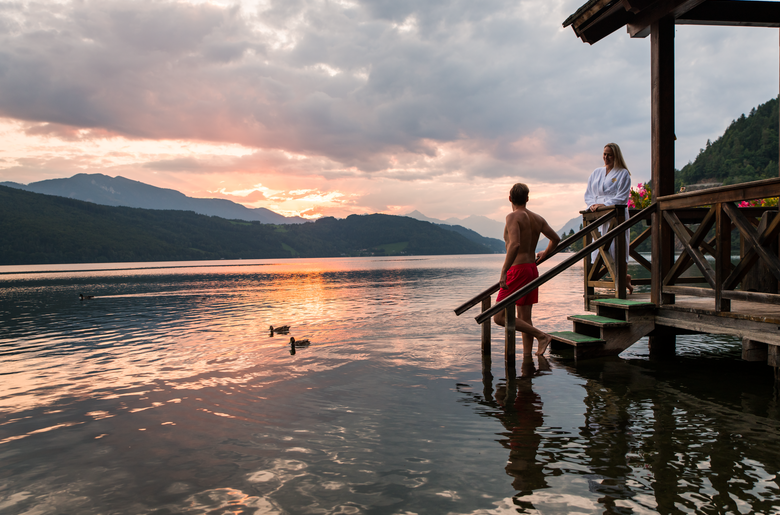 Paar steht am Steg der Seesauna zum Sonnenuntergang | © Michael Stabentheiner / Kärnten Werbung GmbH