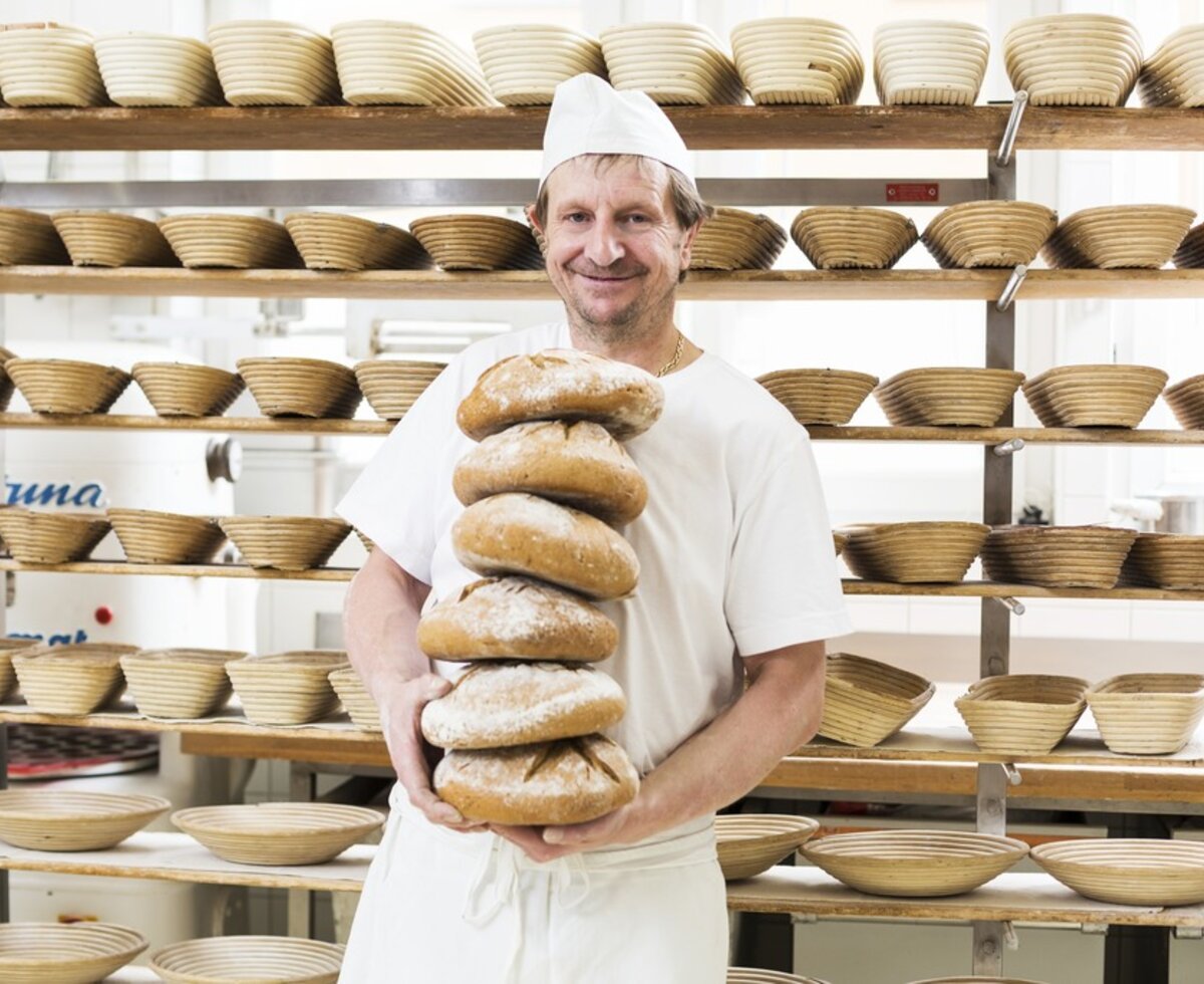 Slow Food Kärnten - Brot backen | © Wolfgang Hummer / Kärnten Werbung GmbH Bäcker steht mit gestapelten Broten in der Backstube | © Wolfgang Hummer / Kärnten Werbung GmbH