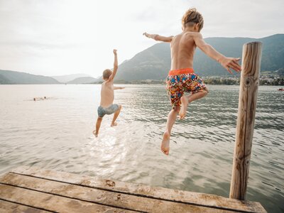Zwei Kinder springen vom Steg in den Ossiacher See | © Martin Hofmann / Region Villach - Faaker See - Ossiacher See