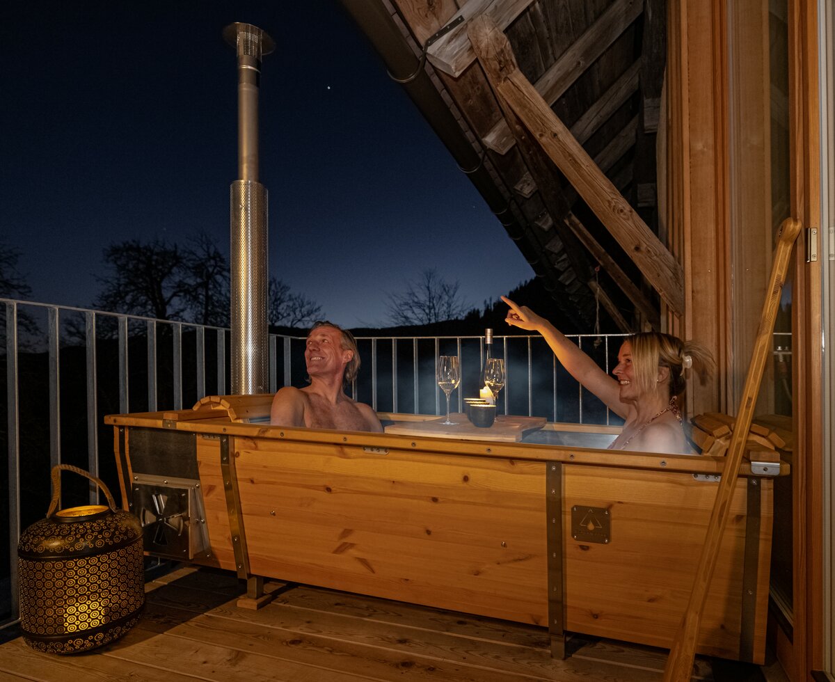 Paar in der Holzwanne | © Urlaub am Bauernhof Kärnten/ Achim Mandler Paar sitzt in der Holzwanne am Balkon | © Urlaub am Bauernhof Kärnten/ Achim Mandler