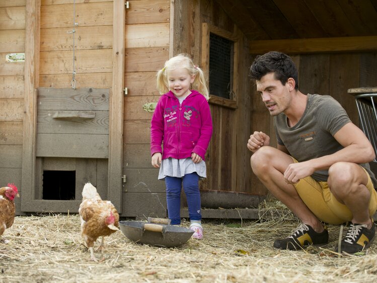 Man with child in the chicken pen  | © Urlaub am Bauernhof Niederösterreich / Karin Lohberger