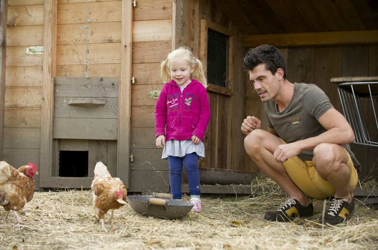 Man with child in the chicken pen  | © Urlaub am Bauernhof Niederösterreich / Karin Lohberger