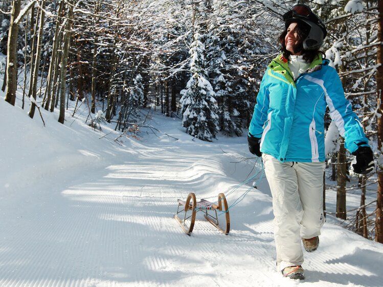 Woman walking with toboggan in winter landscape | © Mostviertel Tourismus / weinfranz.at