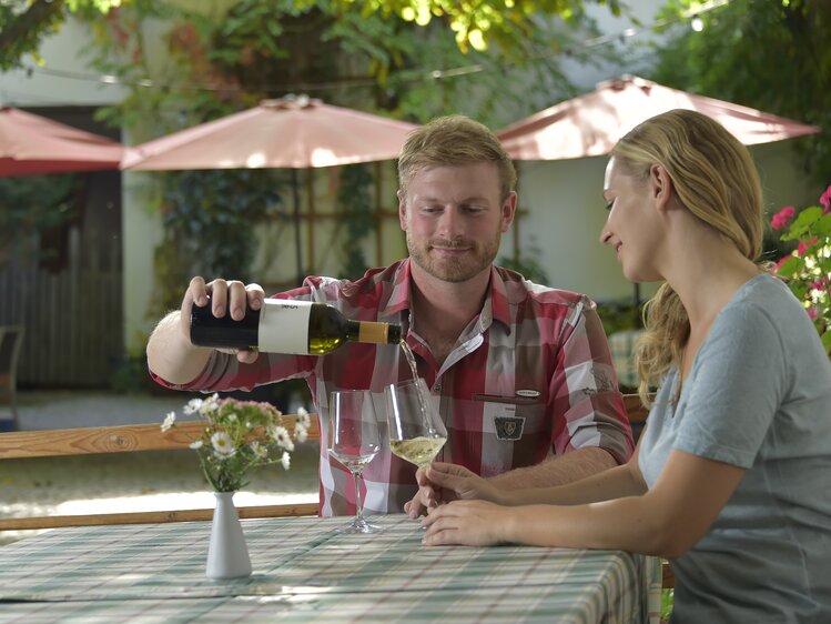 Couple sits at the Heuriger and drinks wine | © Urlaub am Winzerhof / Ralph Fischbacher