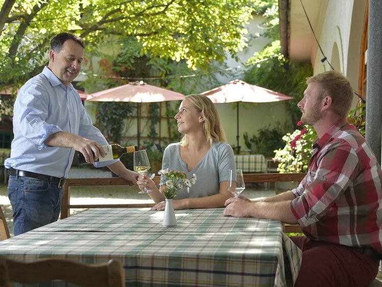 Pouring wine at the Heuriger | © Urlaub am Winzerhof / Ralph Fischbacher