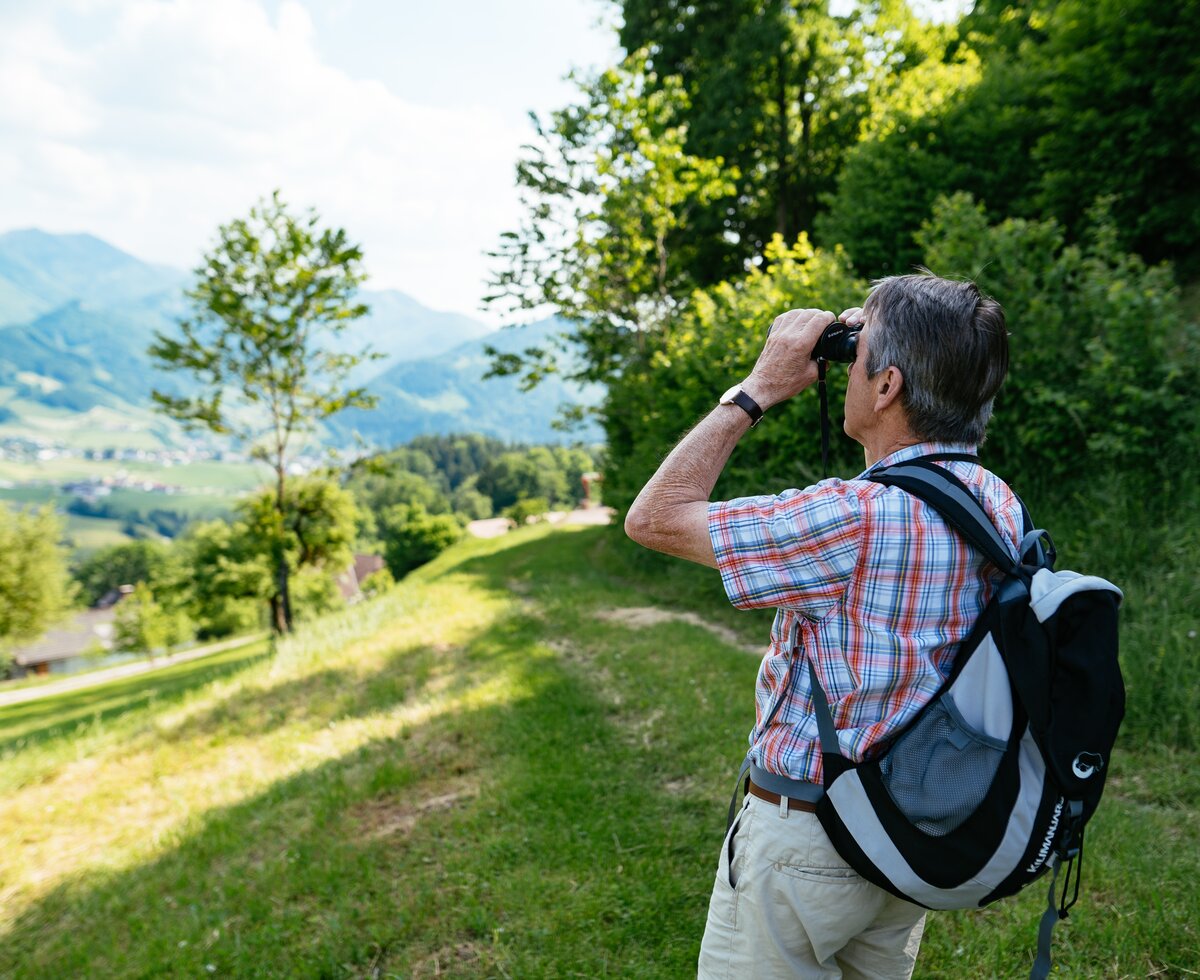 Mann schaut beim Wandern mit dem Fernglas ins Land | © Urlaub am Bauernhof Oberösterreich / Daniel Gollner