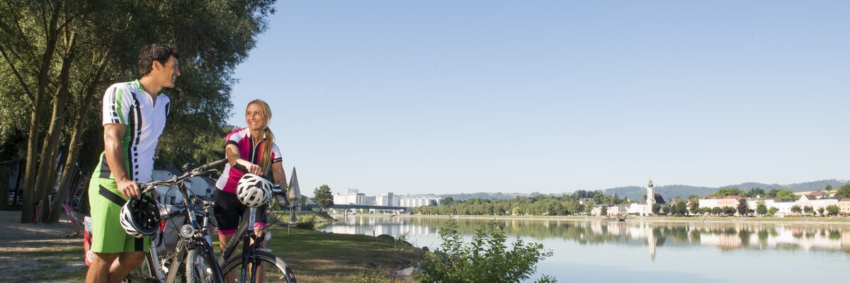 Paar am Fahrrad macht Pause an der Donau am Donauradweg Oberösterreich | © Oberösterreich Tourismus GmbH / Hermann Erber