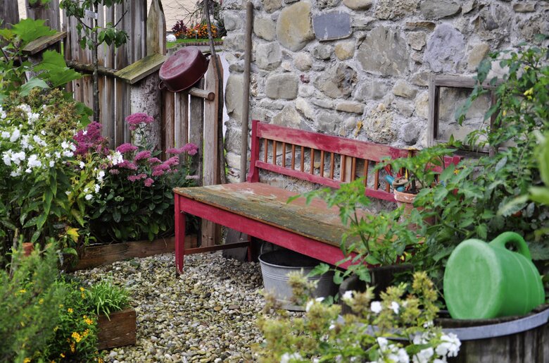 Rote Bank zum Entspannen mitten im Garten | © Urlaub am Bauernhof Oberösterreich / Harald Puchegger