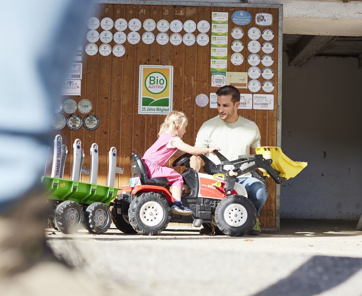 Mädchen fährt mit Trettraktor | © Urlaub am Bauernhof Oberösterreich / Alexander Kaiser