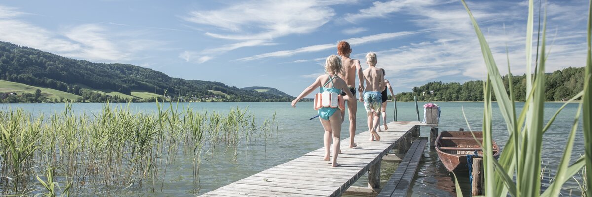 Kinder laufen im Sommer auf einem Steg zum Baden direkt am See | © Urlaub am Bauernhof Oberösterreich / Robert Maybach