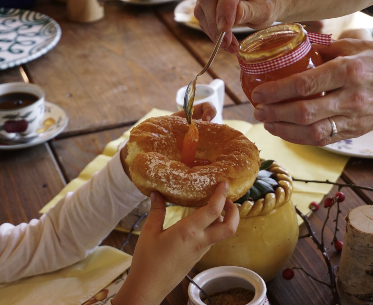 Bauernkrapfen wird mit einem Löffel Marillenmarmelade gefüllt | © Urlaub am Bauernhof Oberösterreich / Harald Puchegger