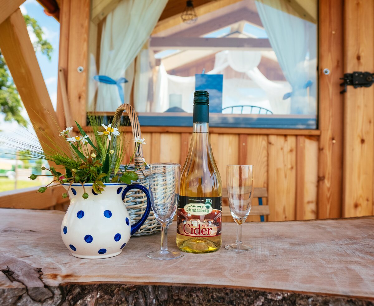 Köstlicher Cider vom Bauernhof | © Urlaub am Bauernhof Oberösterreich / Daniel Gollner Eine Flasche Cider, ein bunt bemalter Krug und zwei Gläser stehen auf dem Tisch | © Urlaub am Bauernhof Oberösterreich / Daniel Gollner