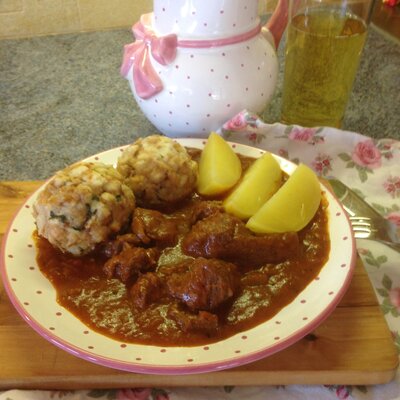 Ein Teller Mostgulasch mit Semmelknödeln und Erdäpfel, dazu ein Glas Most | © Urlaub am Bauernhof Oberösterreich / Angelika Gösweiner