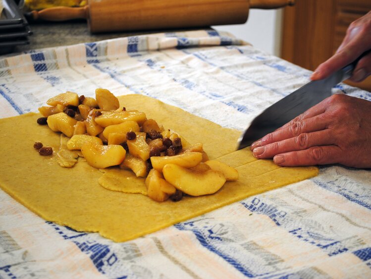 Der Teig des Apfelstrudels wird vor dem Einschlagen in Streifen geschnitten. | © Urlaub am Bauernhof Oberösterreich / Manuela Edlbauer