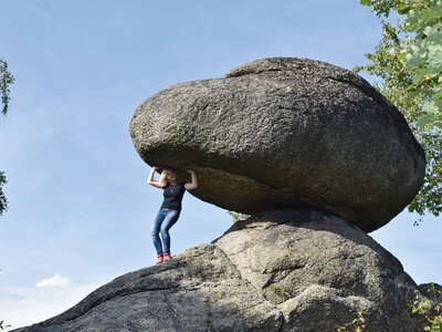 Wackelt ein Wackelstein wirklich? | © Urlaub am Bauernhof Oberösterreich / Harald Puchegger Frau versucht an einem riesigen Wackelstein zu wackeln | © Urlaub am Bauernhof Oberösterreich / Harald Puchegger