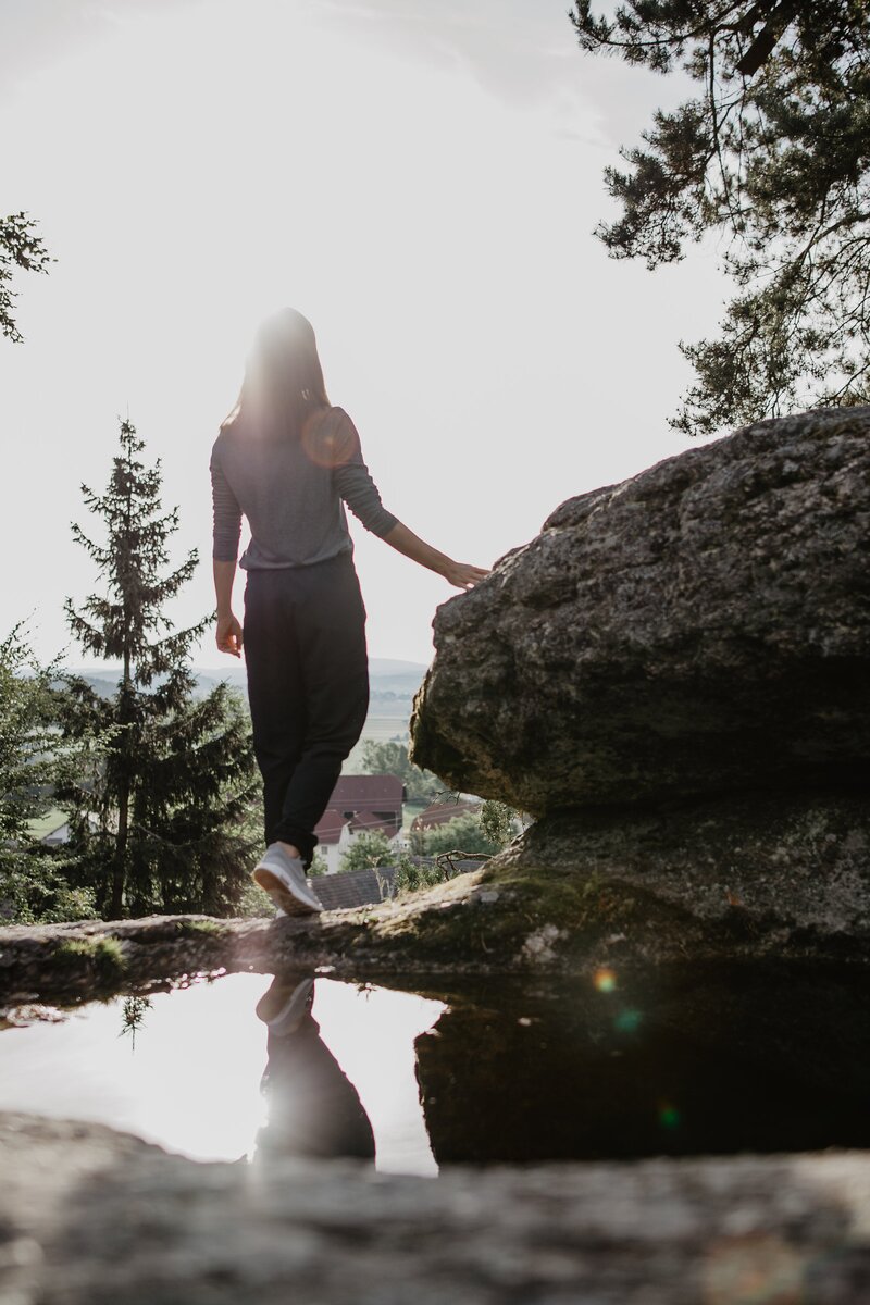 Frau steht an einem Granitfelsen, Mühlviertel | © Oberösterreich Tourismus GmbH / Patrick Langwallner